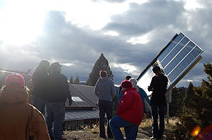 Energy Corps members inspect a solar panel
